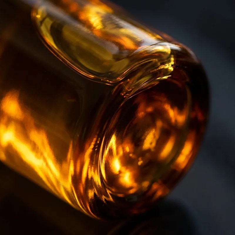 Detaliu macro al sticlei ambrie, cu lumină aurie refractată